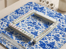 Blue mahjong mat with an Asian garden landscape pattern showing pagodas, birds, and flowers.
