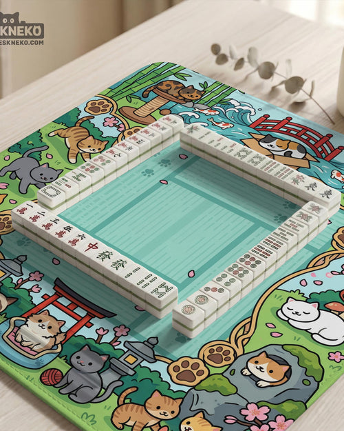 Mint green square mahjong mat with a Japanese garden style border featuring cats, koi fish, bamboo, blossoms, and small scenic details.