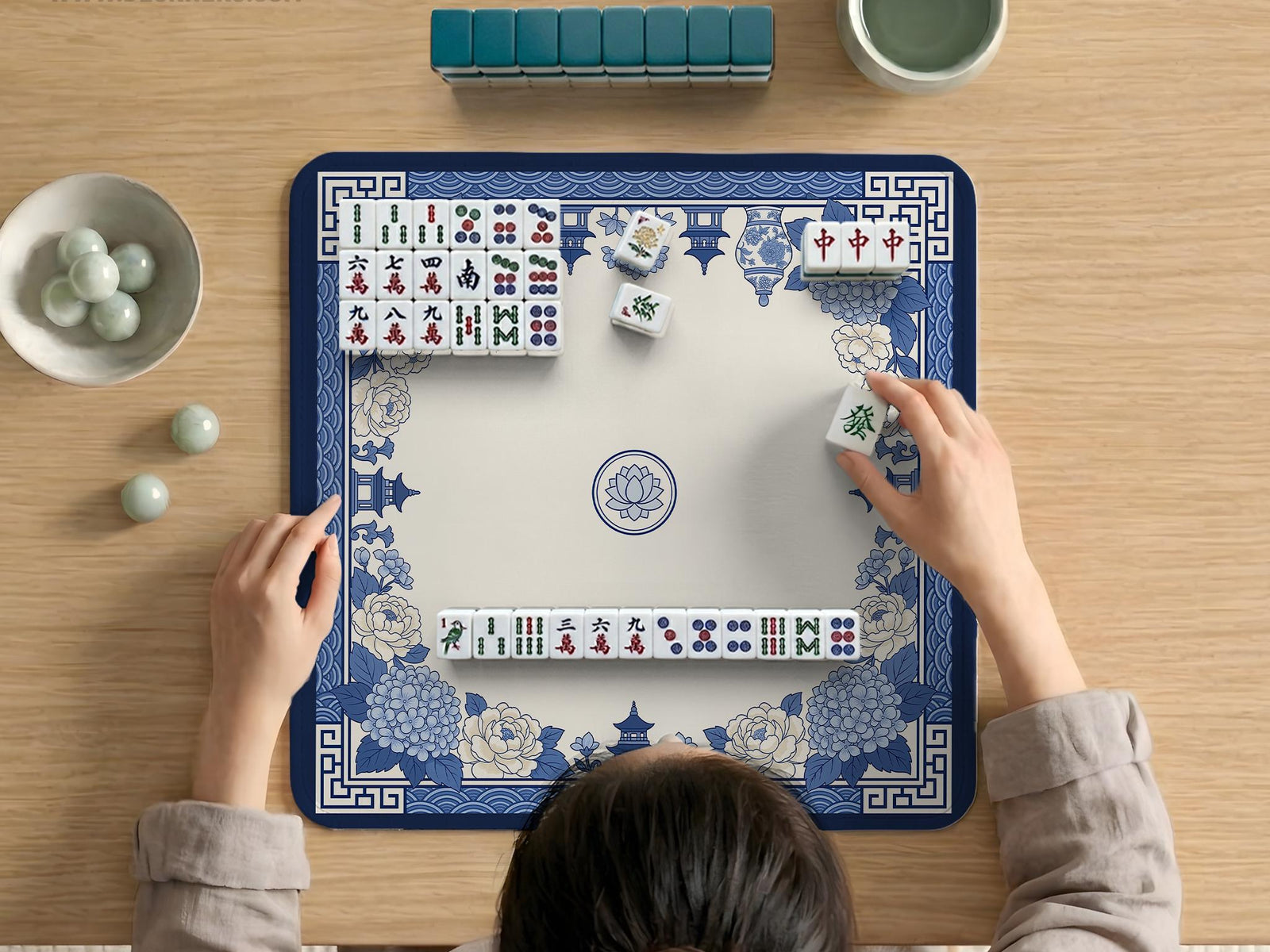 A square mahjong mat with a blue and white chinoiserie floral border and a plain center area.