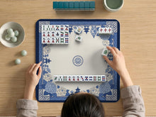A square mahjong mat with a blue and white chinoiserie floral border and a plain center area.