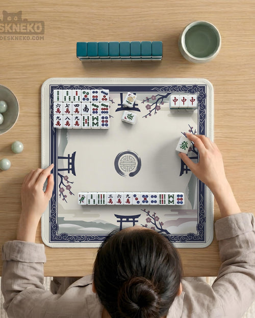 Navy and cream square mahjong mat with cherry blossom branches and a torii gate design, shown as a small tabletop play surface.