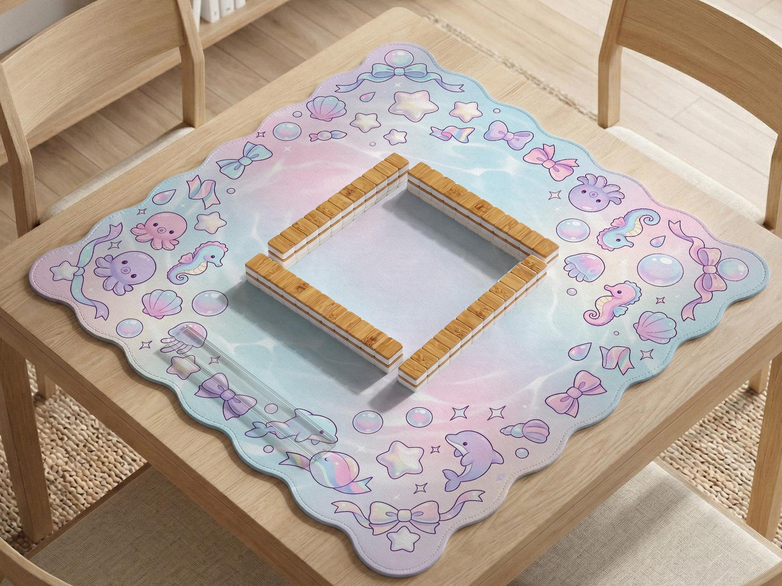 Mahjong mat with a light blue, pink, and lavender border showing shells, bows, bubbles, dolphins, and seahorses around an open center.