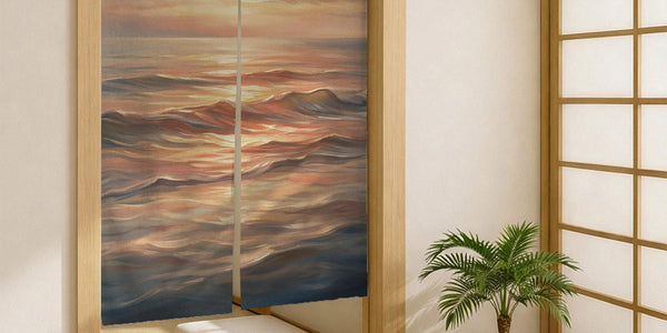 A Japanese-style split door curtain with an abstract ocean sunset design in peach, blush, cream, and muted blue.