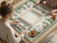Square mahjong table mat with a bamboo garden design, green bamboo, stacked stones, and flowing sand lines on a cream background.