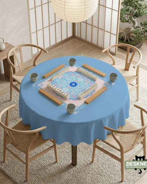 Pastel blue and pink floral square table cover with a scalloped center medallion and ornamental border.