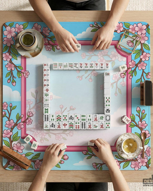 Floral cherry blossom mahjong mat in pink and sky blue with sakura branches and cloud details around an open center area.