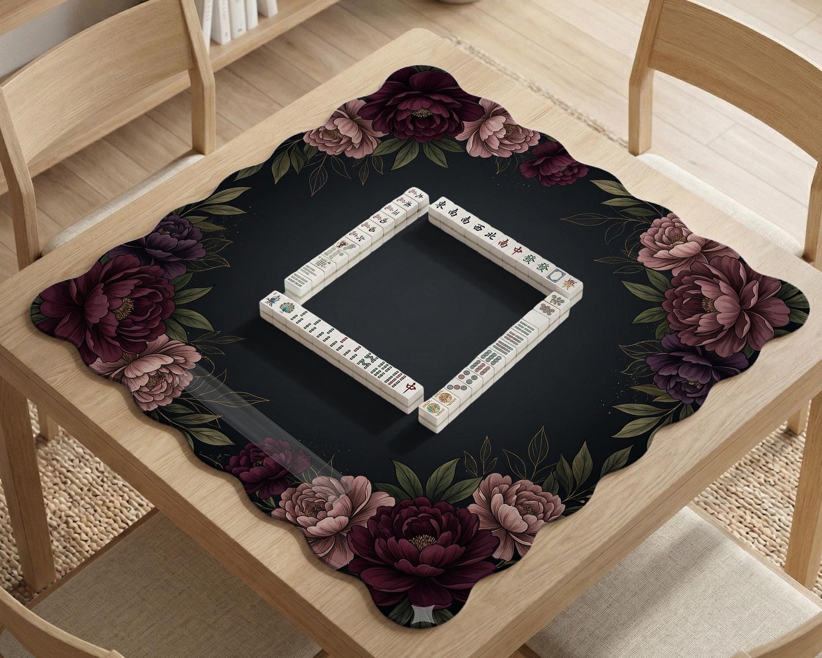 A floral mahjong mat with a dark background and a peony border in burgundy, blush, and olive tones.