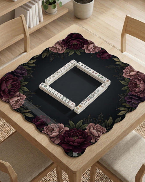 A floral mahjong mat with a dark background and a peony border in burgundy, blush, and olive tones.