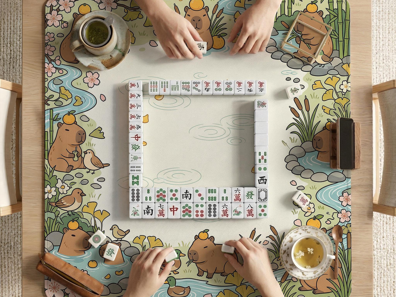 A square mahjong mat with a capybara illustration, pastel spring garden border, sakura blossoms, ducks, bamboo, streams, and a blank center play area.