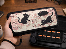 Switch case with black cats and cherry blossoms on a light pastel background.