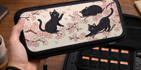 Switch case with black cats and cherry blossoms on a light pastel background.