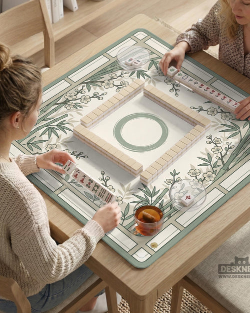 Sage green square mahjong mat with bamboo stalks and cherry blossom branches printed across the surface.