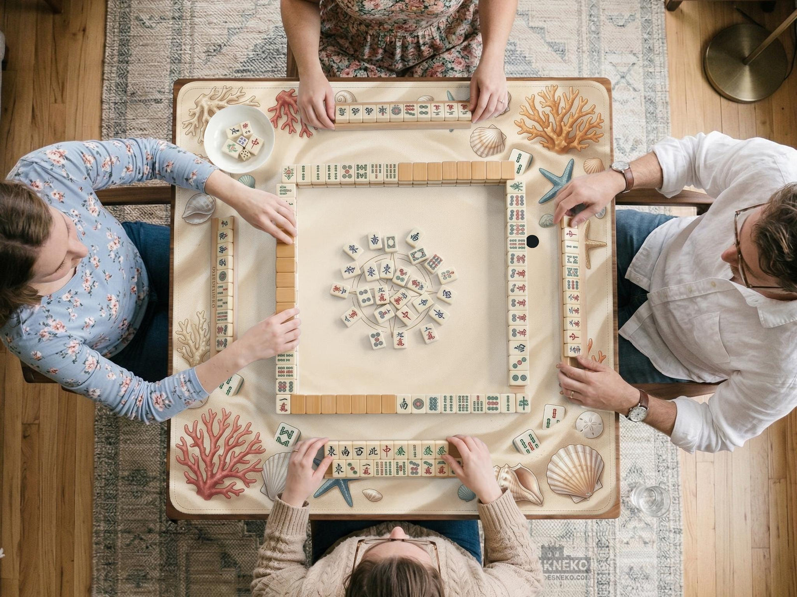 A rectangular mahjong table mat with a neutral coastal design featuring seashells, coral, and starfish around a blank center.
