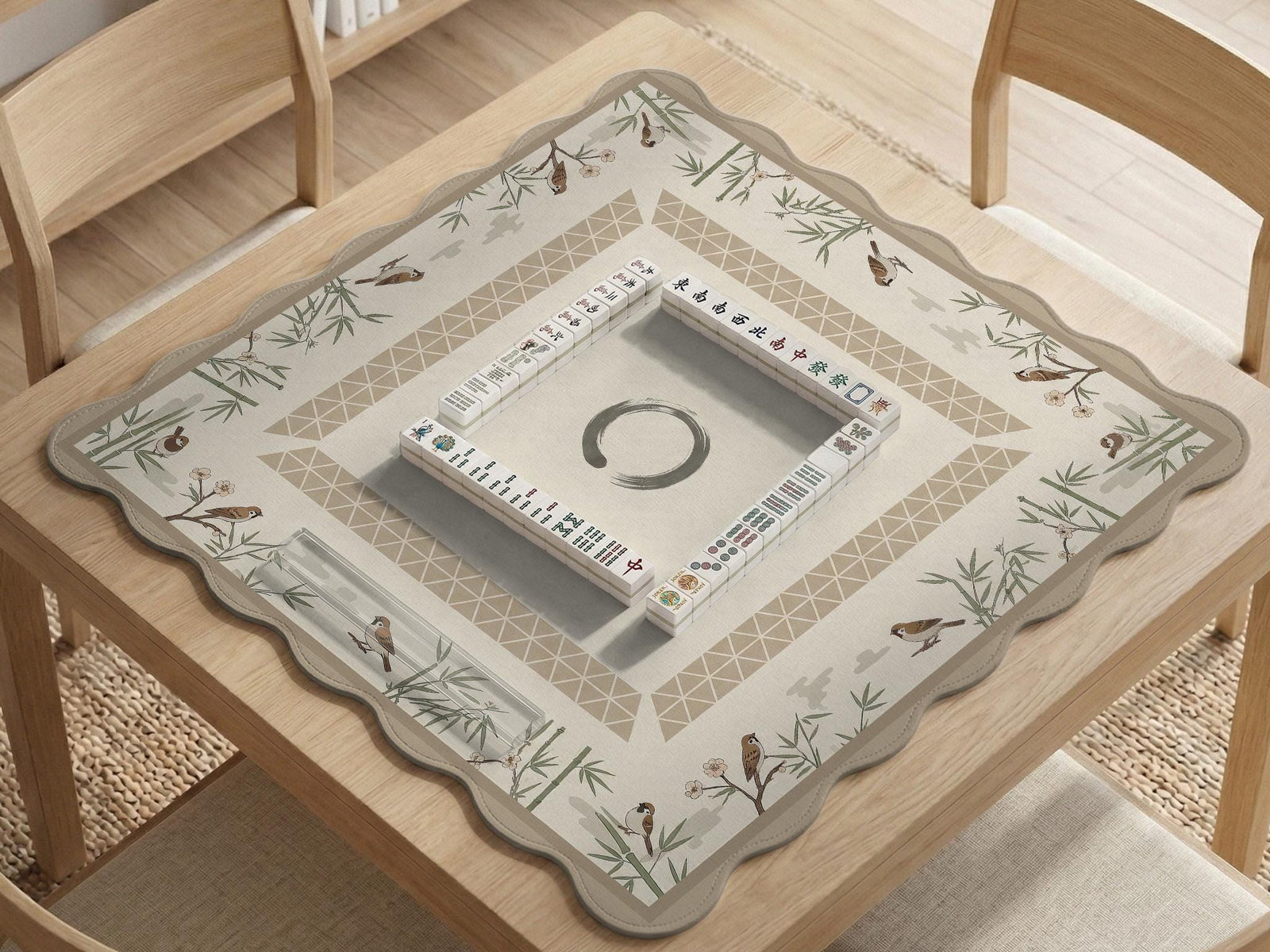 Beige mahjong mat with bamboo accents, small bird illustrations, and a clear center area.