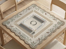 Beige mahjong mat with bamboo accents, small bird illustrations, and a clear center area.