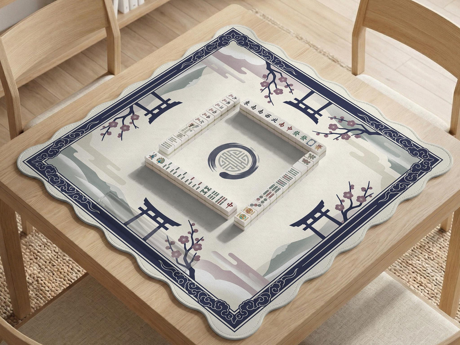 A navy square mahjong mat with a framed center and a sakura and torii design around the edges.