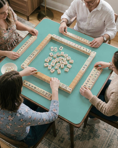 Solid turquoise square mahjong table mat with a scalloped edge.