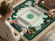 A square mahjong table mat with an emerald green dragon border, jade green center, cream details, and gold art deco accents.