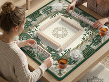 Square mahjong mat with a cream center and a border featuring emerald green dragons, bamboo stalks, cloud shapes, and geometric details.
