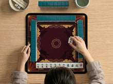 Square mahjong mat with a red, black, and gold dragon design and a dark background.
