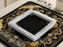Black and gold mahjong mat with a dragon border, ornate cloud details, and a dark center area.