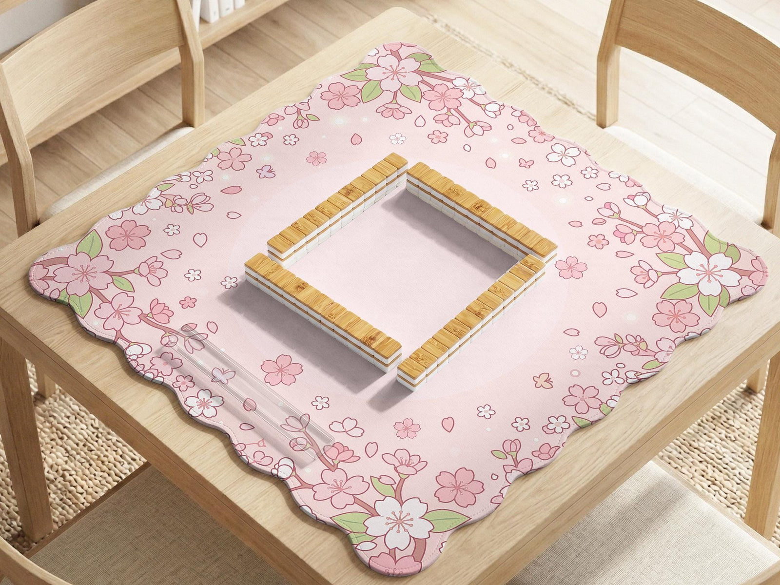 Pink mahjong mat with a scalloped edge and cherry blossom branches around the border, with a plain blush center.