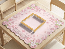 Pink mahjong mat with a scalloped edge and cherry blossom branches around the border, with a plain blush center.