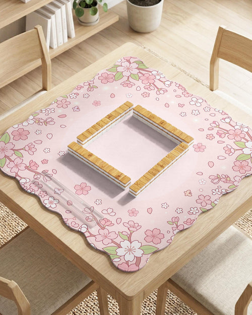 Pink mahjong mat with a scalloped edge and cherry blossom branches around the border, with a plain blush center.