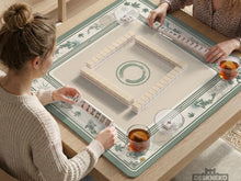 A square sage green mahjong table mat with koi fish, bamboo accents, and a bordered play area.
