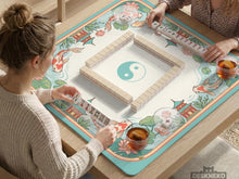 Pastel mahjong mat with a koi fish and lotus pond design, pagoda details, lily pads, and curved water lines.
