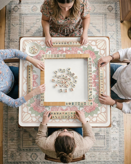 Square pink mahjong mat with hydrangea flowers, bows, a cream and sage floral border, and a blank center play area.