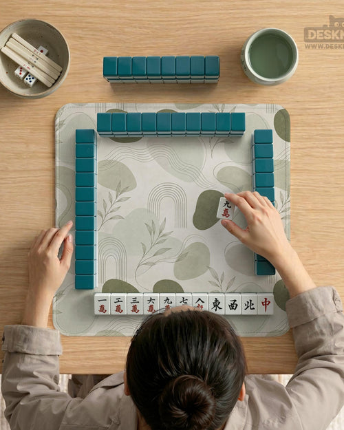 A square sage green mahjong mat with a botanical leaf pattern, fine line details, and a minimalist design.