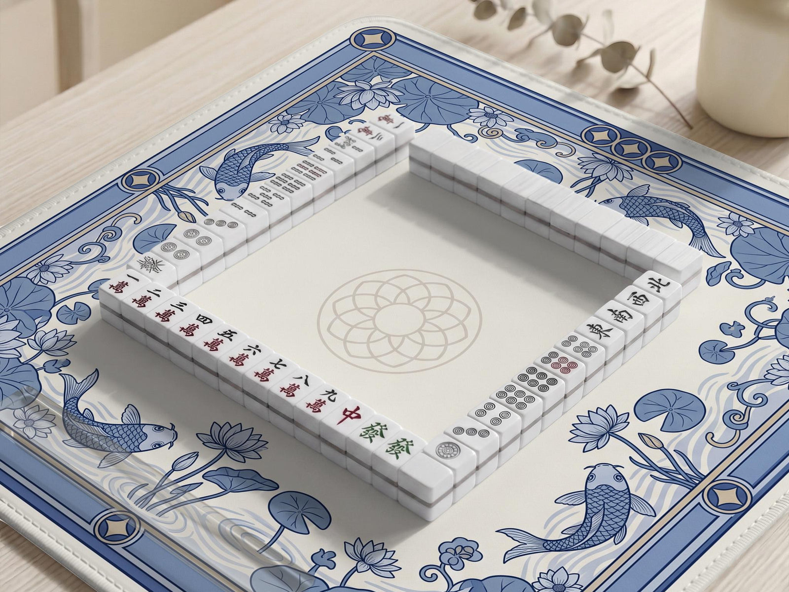 Blue and white mahjong table mat with koi fish, lotus flowers, lily pads, and a decorative border around an open center.