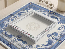 Blue and white mahjong table mat with koi fish, lotus flowers, lily pads, and a decorative border around an open center.