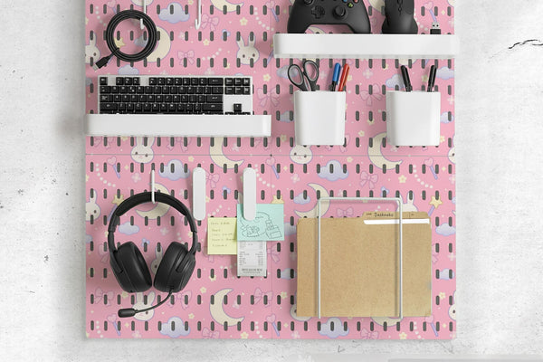 Pink pegboard panels with bunny, moon, cloud, bow, star, and small flower designs, shown as a wall organizer set with containers, shelves, clips, hooks, and a letter holder.
