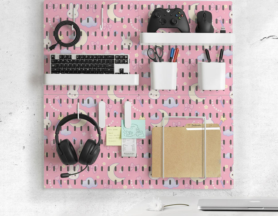 Pink pegboard panels with bunny, moon, cloud, bow, star, and small flower designs, shown as a wall organizer set with containers, shelves, clips, hooks, and a letter holder.