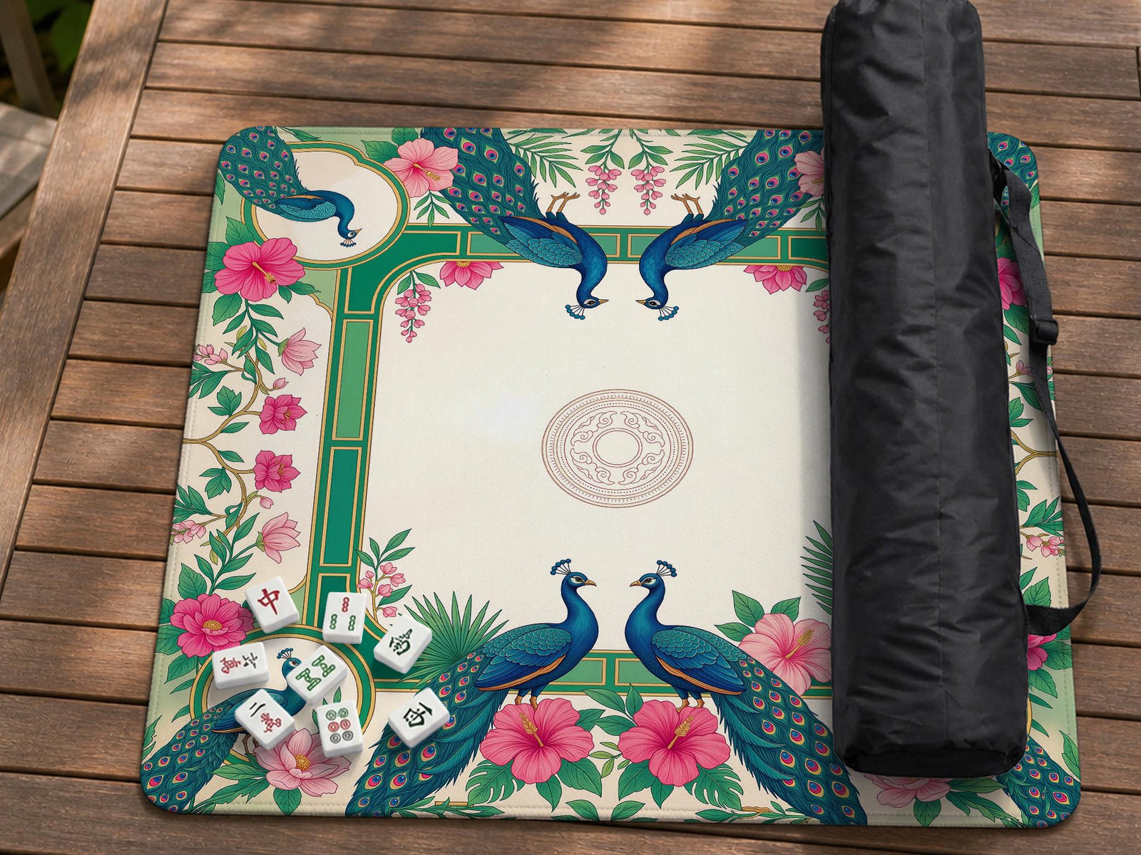 A square mahjong mat with teal peacocks, pink hibiscus flowers, green borders, cream open space, and gold accents.