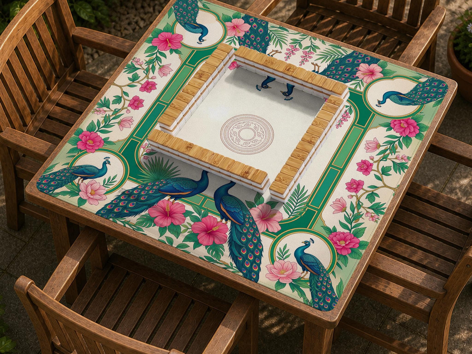 A square mahjong mat with mirrored peacocks, pink hibiscus flowers, leafy botanical details, green panels, cream space, and decorative gold borders.