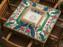 A square mahjong mat with mirrored peacocks, pink hibiscus flowers, leafy botanical details, green panels, cream space, and decorative gold borders.