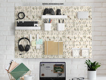 Cream pegboard panels with a botanical flower pattern, pale green leaves, and blush accents shown with shelves, hooks, containers, clips, and a letter holder.