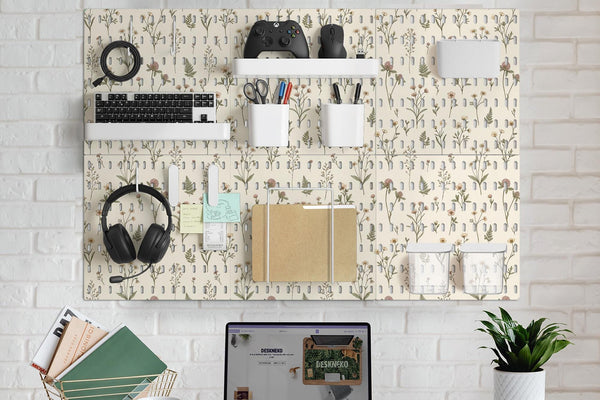 Cream pegboard panels with a botanical flower pattern, pale green leaves, and blush accents shown with shelves, hooks, containers, clips, and a letter holder.