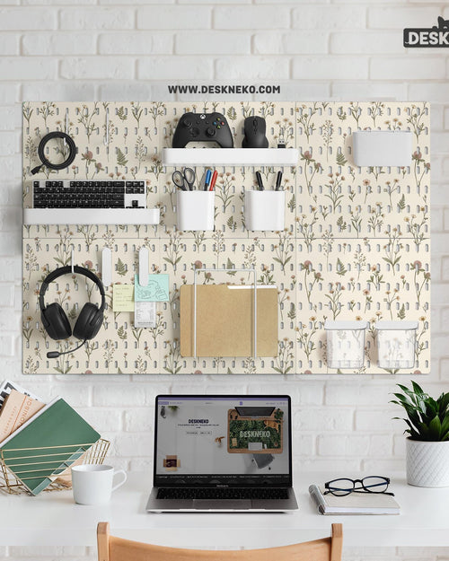 Cream pegboard panels with a botanical flower pattern, pale green leaves, and blush accents shown with shelves, hooks, containers, clips, and a letter holder.