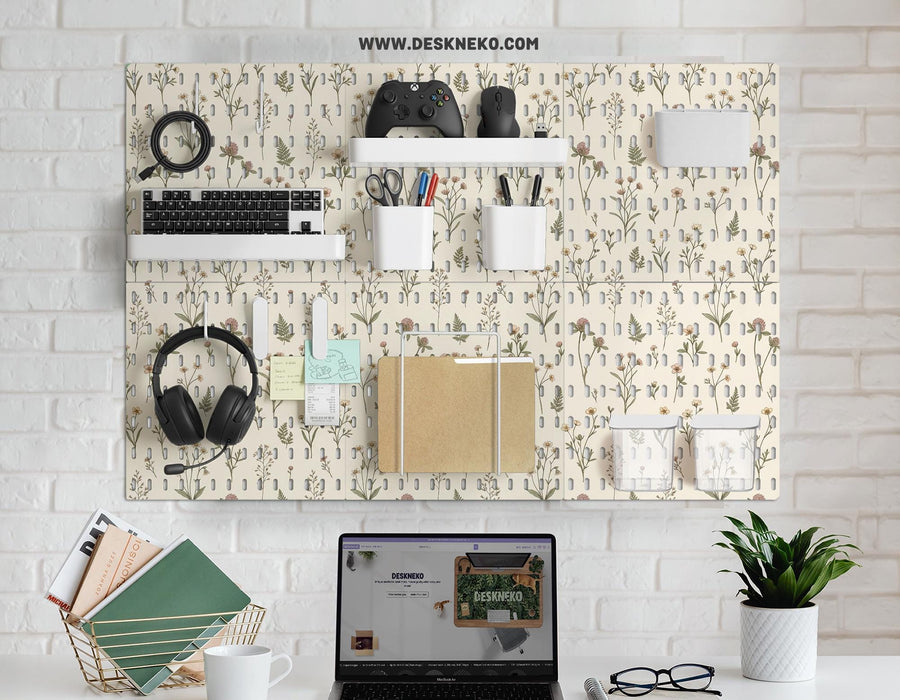 Cream pegboard panels with a botanical flower pattern, pale green leaves, and blush accents shown with shelves, hooks, containers, clips, and a letter holder.