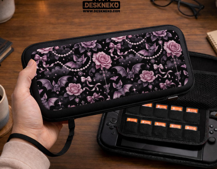 A black Switch carrying case with a pink gothic rose print, small bats, ribbon bows, pearl chain details, and tiny sparkles.