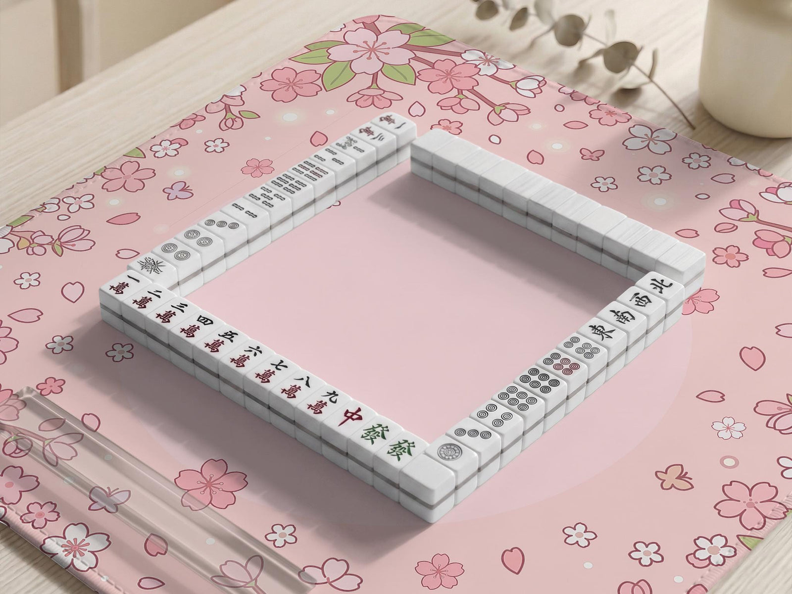 Pink mahjong mat with cherry blossom flowers, scattered petals, and a floral frame on a pastel background.