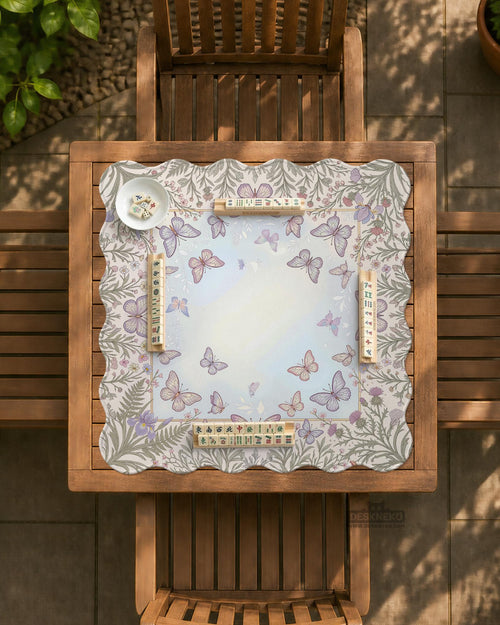 Square mahjong mat with a scalloped edge, floral and butterfly artwork in pale blue, cream, lavender, blush pink, and sage green, and a lighter center area.