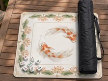 Ivory square mahjong mat with watercolor koi fish, lotus flowers, peach blossoms, sage leaves, and a thin gold border.