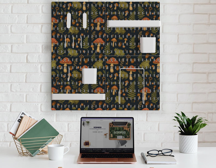 Four charcoal pegboard panels with mushrooms, frogs, leaves, and acorns, arranged as a wall organizer with hooks, shelves, containers, clips, and holders.