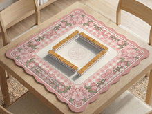 Square pink mahjong mat with a gingham border, floral corner details, and ribbon accents on a light background.
