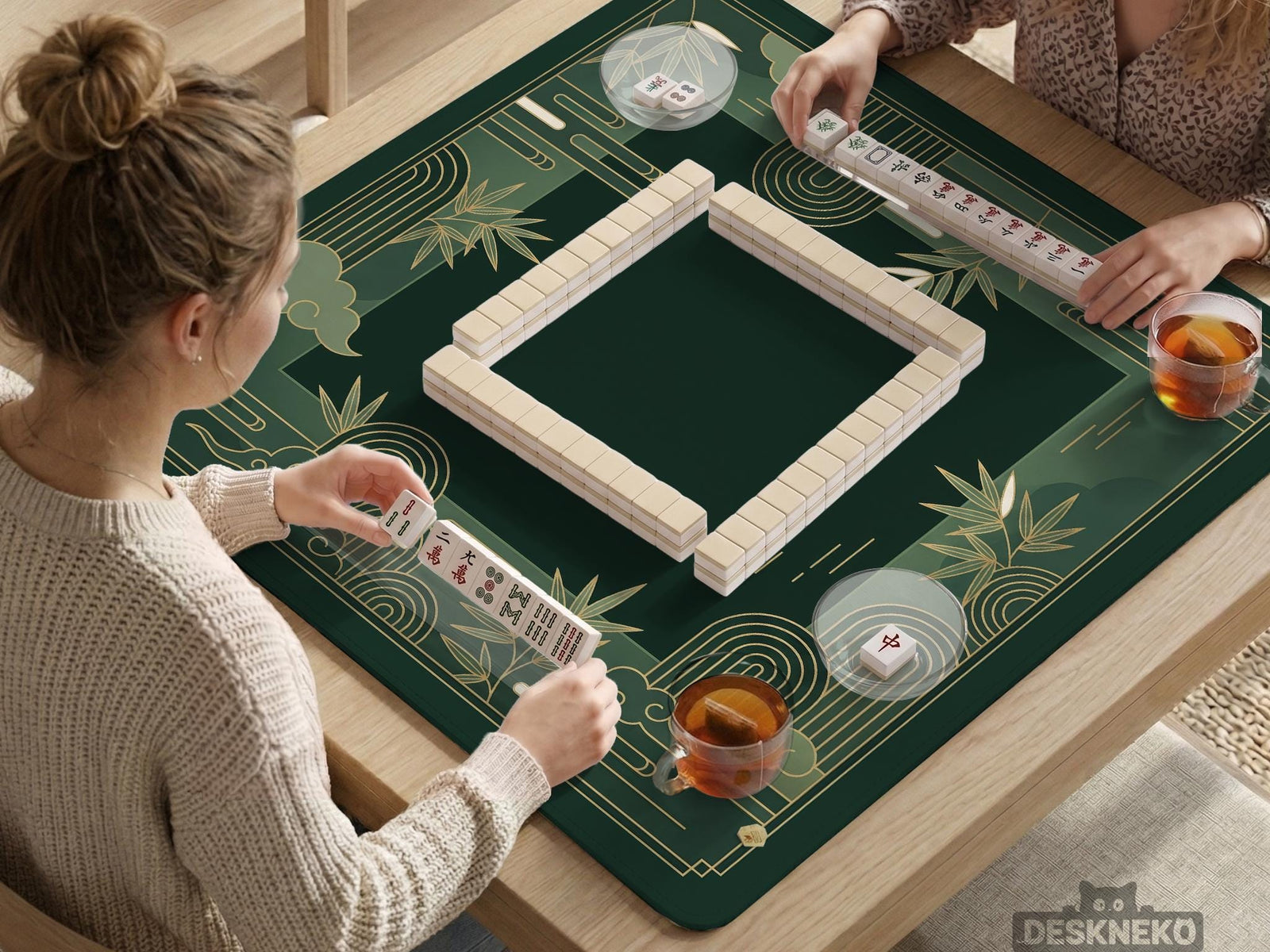 Square emerald green mahjong mat with bamboo line art, gold geometric cloud shapes, and a plain center playing area.